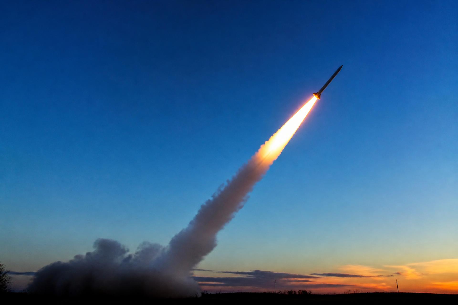 A model rocket lifting off from a launch pad with an open sky behind it